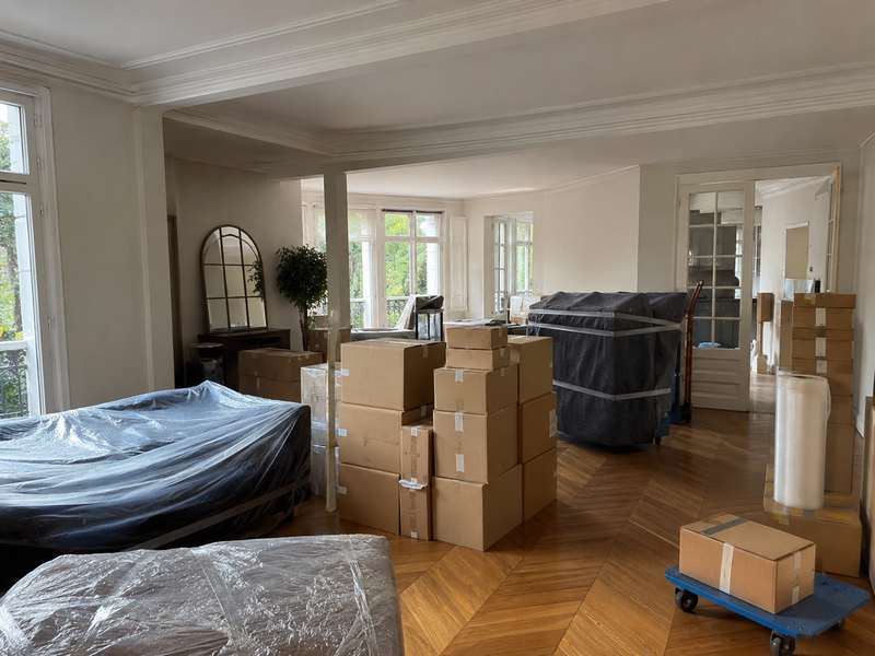 Pièce en cours de déménagement, cartons étiquetés et meubles protégés