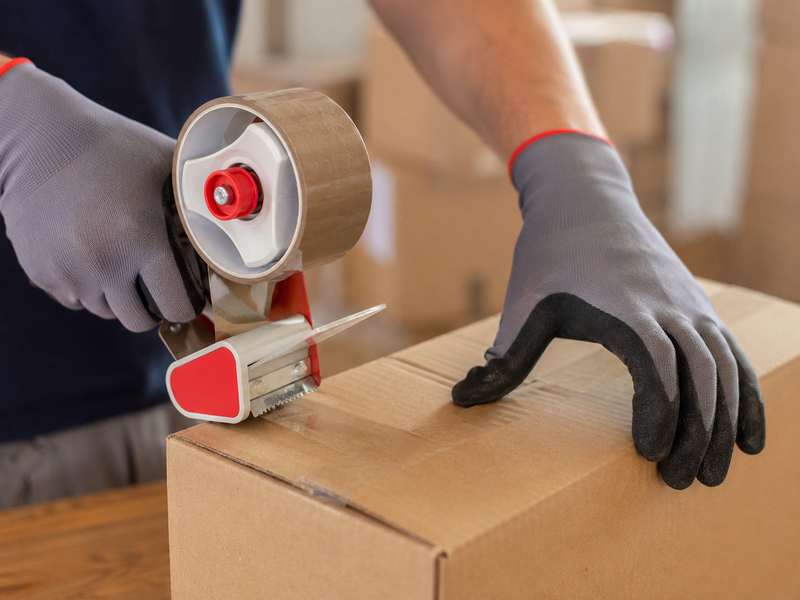 Préparation et fermeture d'un carton de déménagement